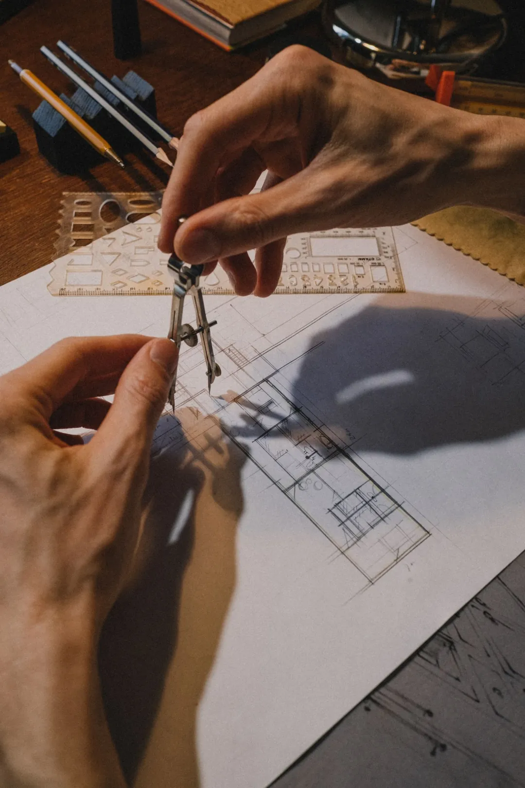 Manos trabajando sobre un plano arquitectónico